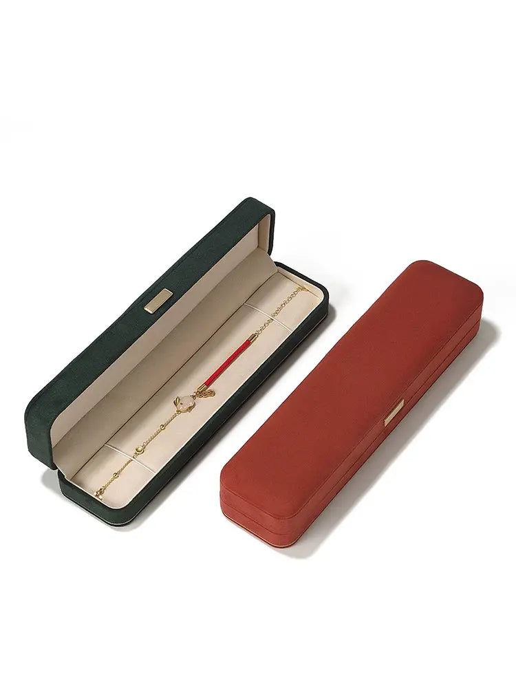 Long chain boxes in dark green and carmine, one open showing the lining
